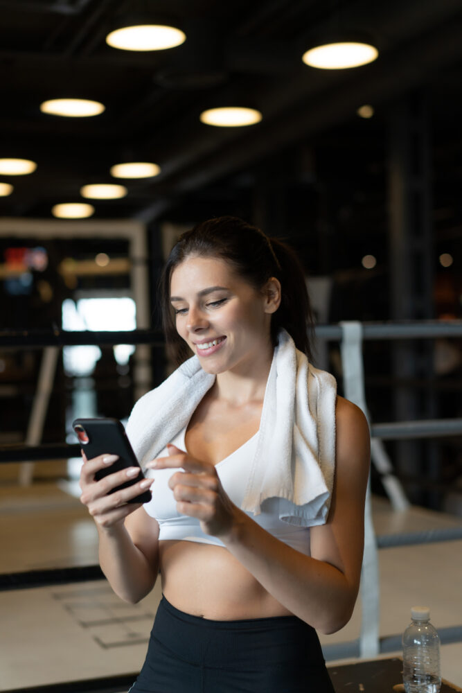 girl texting while taking break gym reads message